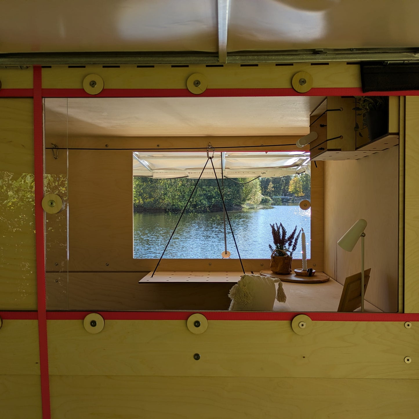 Blick durch die Fenster des Kiubiq Bauwagen Wohnkubus am See