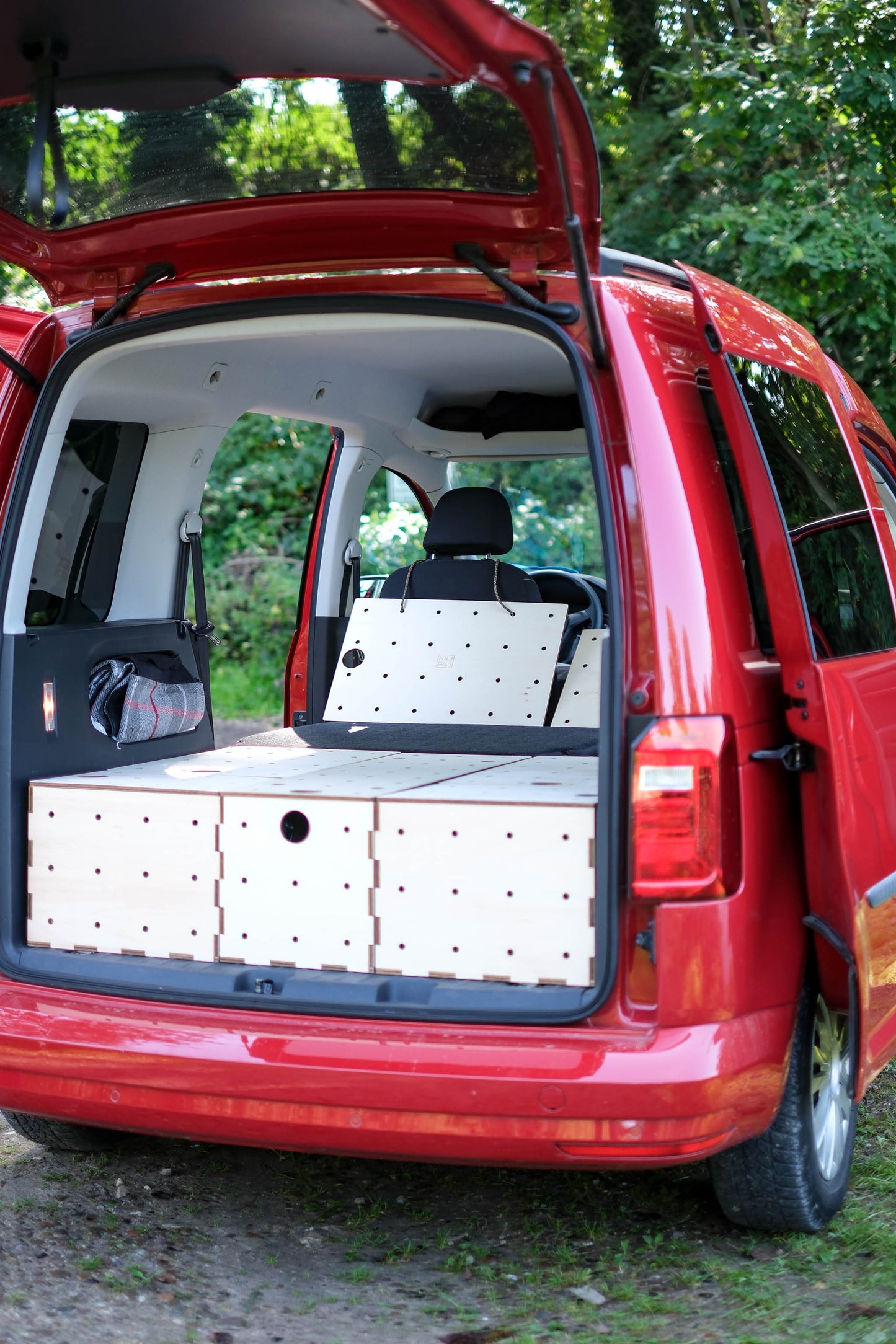 KIUBIQ Caddy Camping Set im Kofferraum eines VW Caddy, bestehend aus fünf Holzboxen