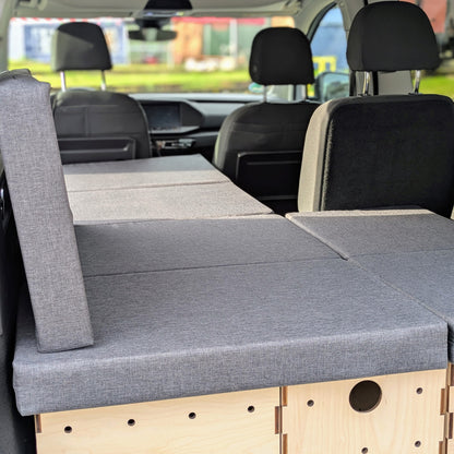 KIUBIQ Caddy Camping Set im VW Caddy: modulare Boxen mit grauen Polstern im Lounge-Modus, Rücksitz bleibt nutzbar.