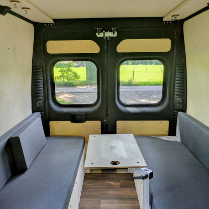 Modularer Fiat Ducato Camperausbau – Innenansicht mit Sofa-Modulen und klappbarem Holztisch im Loungebereich