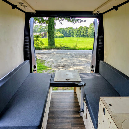 Modularer Camperausbau für den Fiat Ducato in offener Lounge-Konfiguration mit Blick ins Grüne – Sitzbank-System mit flexibler Tischlösung