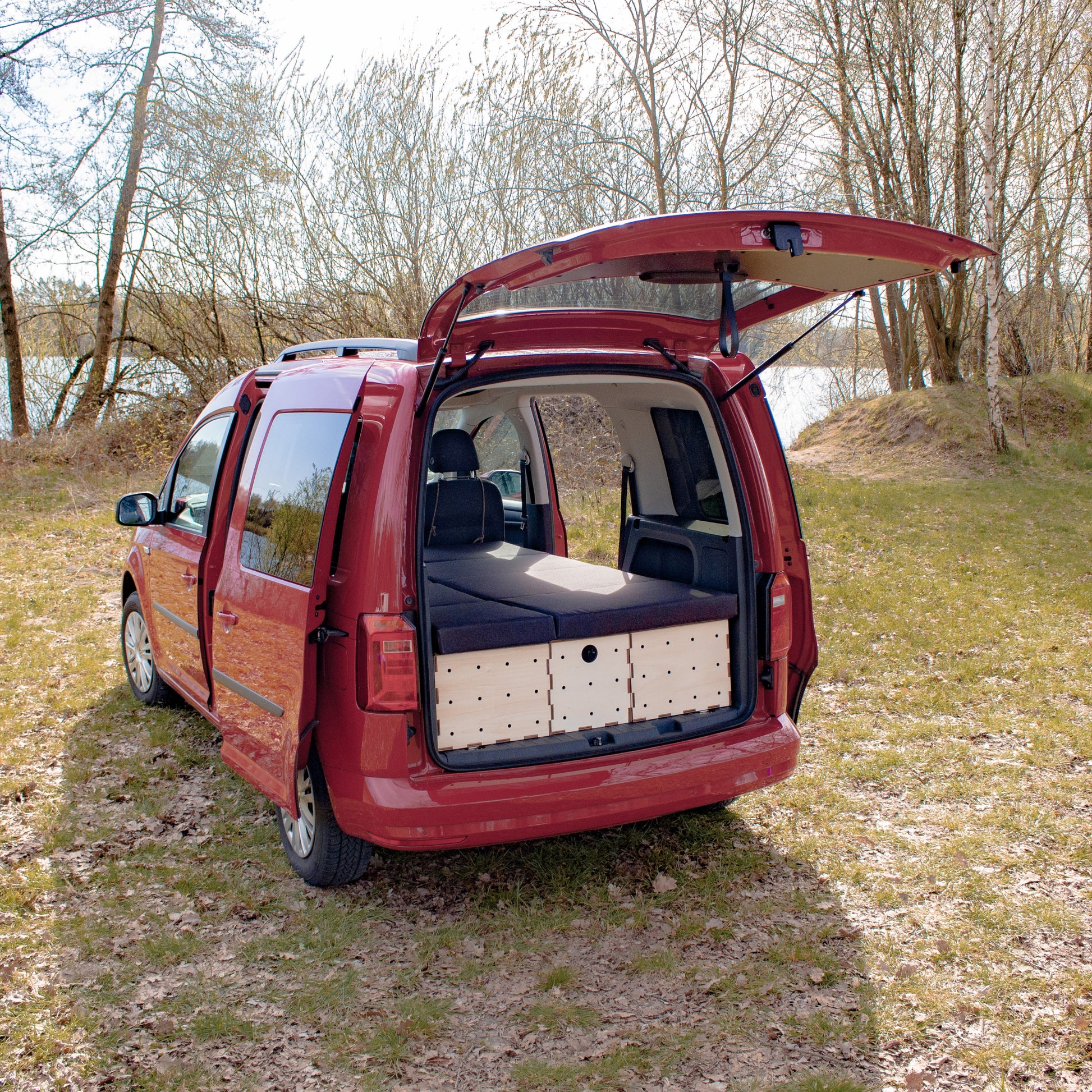 Liegefläche im VW Caddy mit zweigeteilter Matratze, ausgestattet mit dem KIUBIQ Camping Set